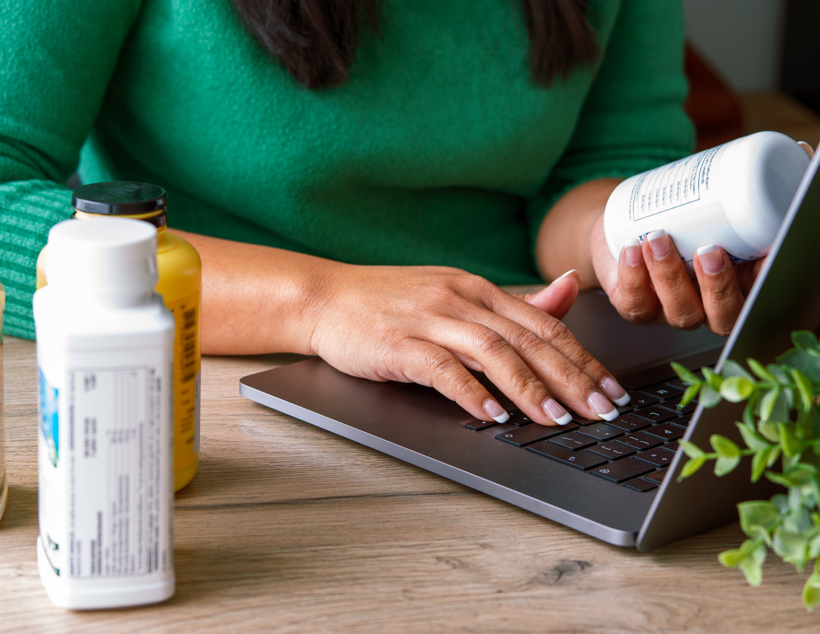 Woman holding bottle looking for lion’s mane supplements online.