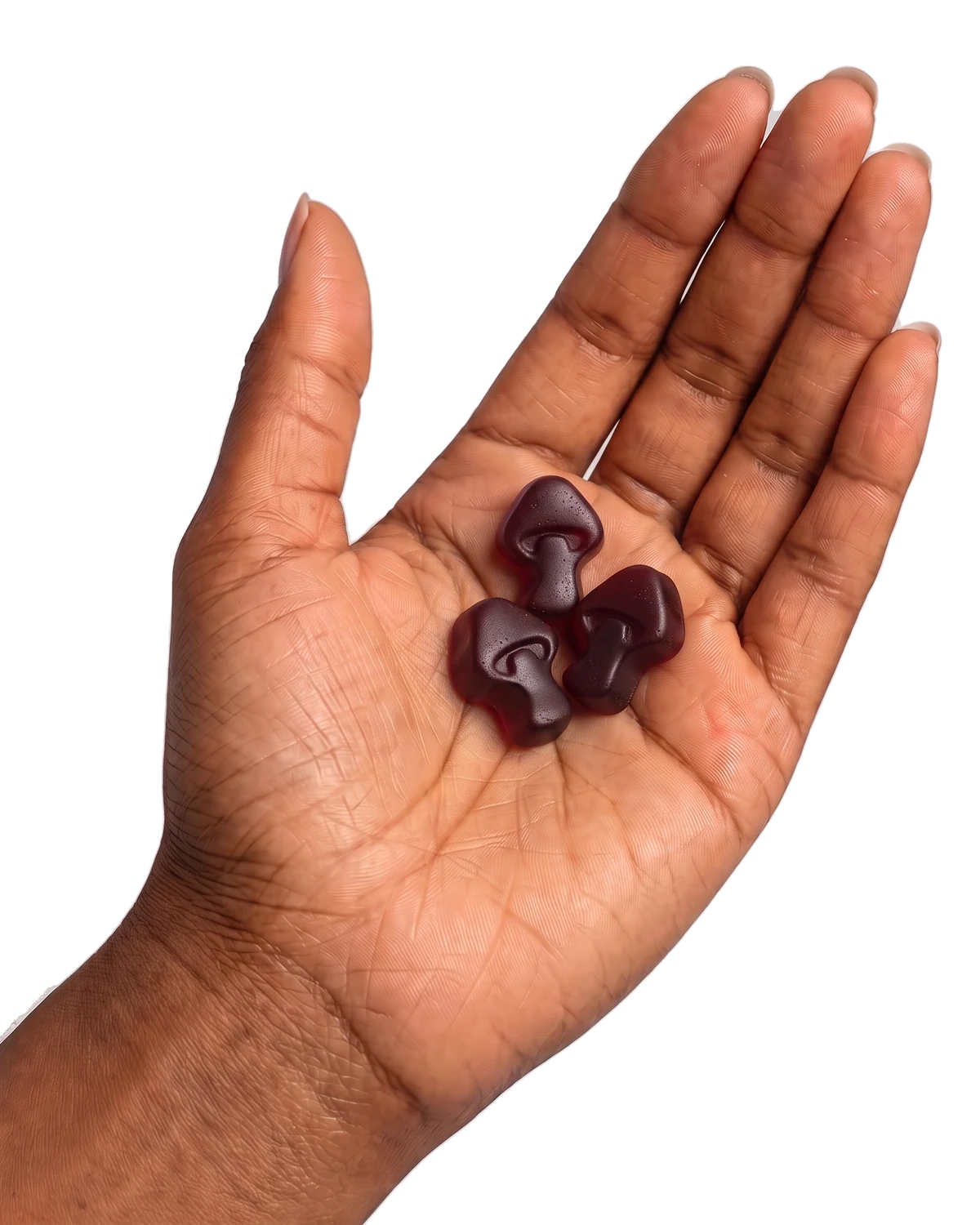 An open palm holding three mushroom-shaped gummies.