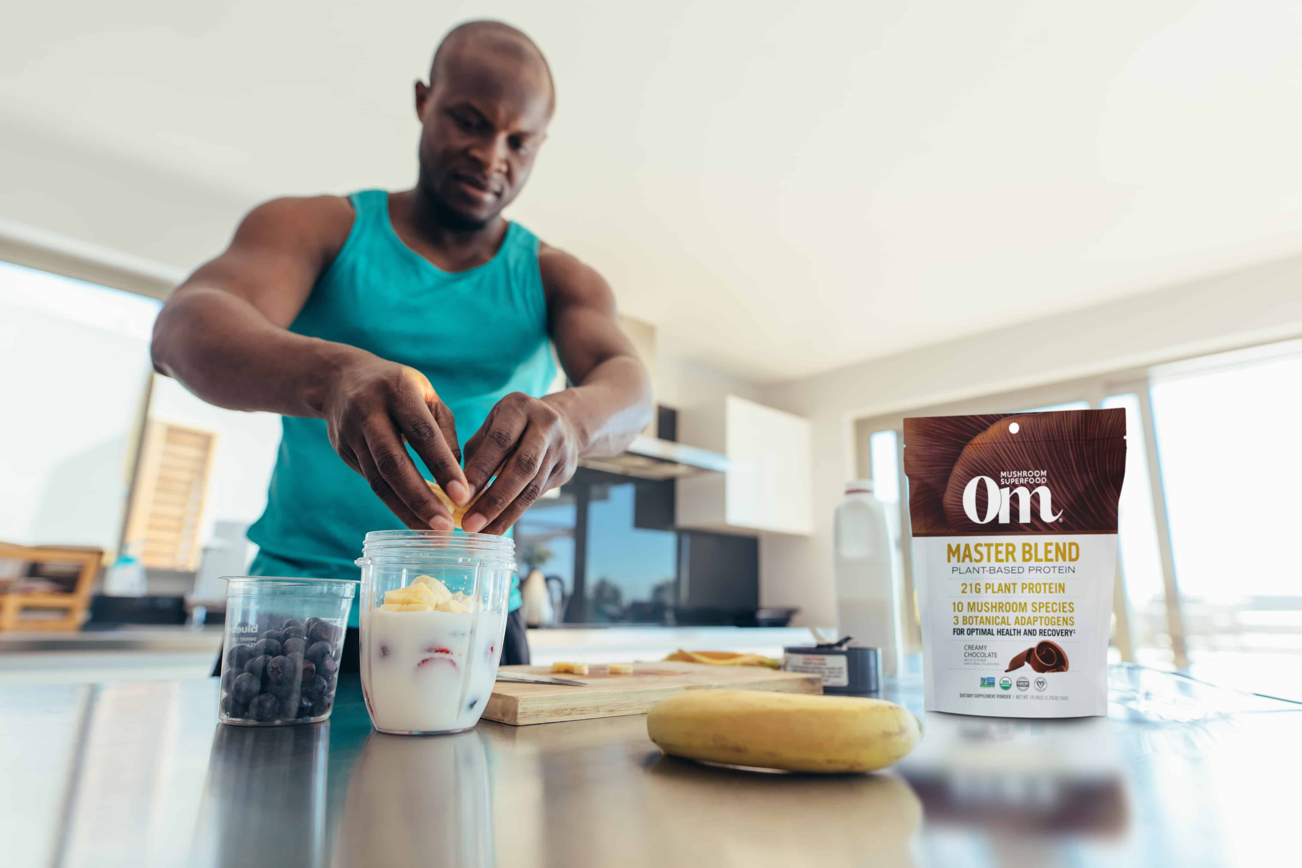 Man preparing protein shake with Om’s Master Blend’s mushroom benefits for muscle growth.