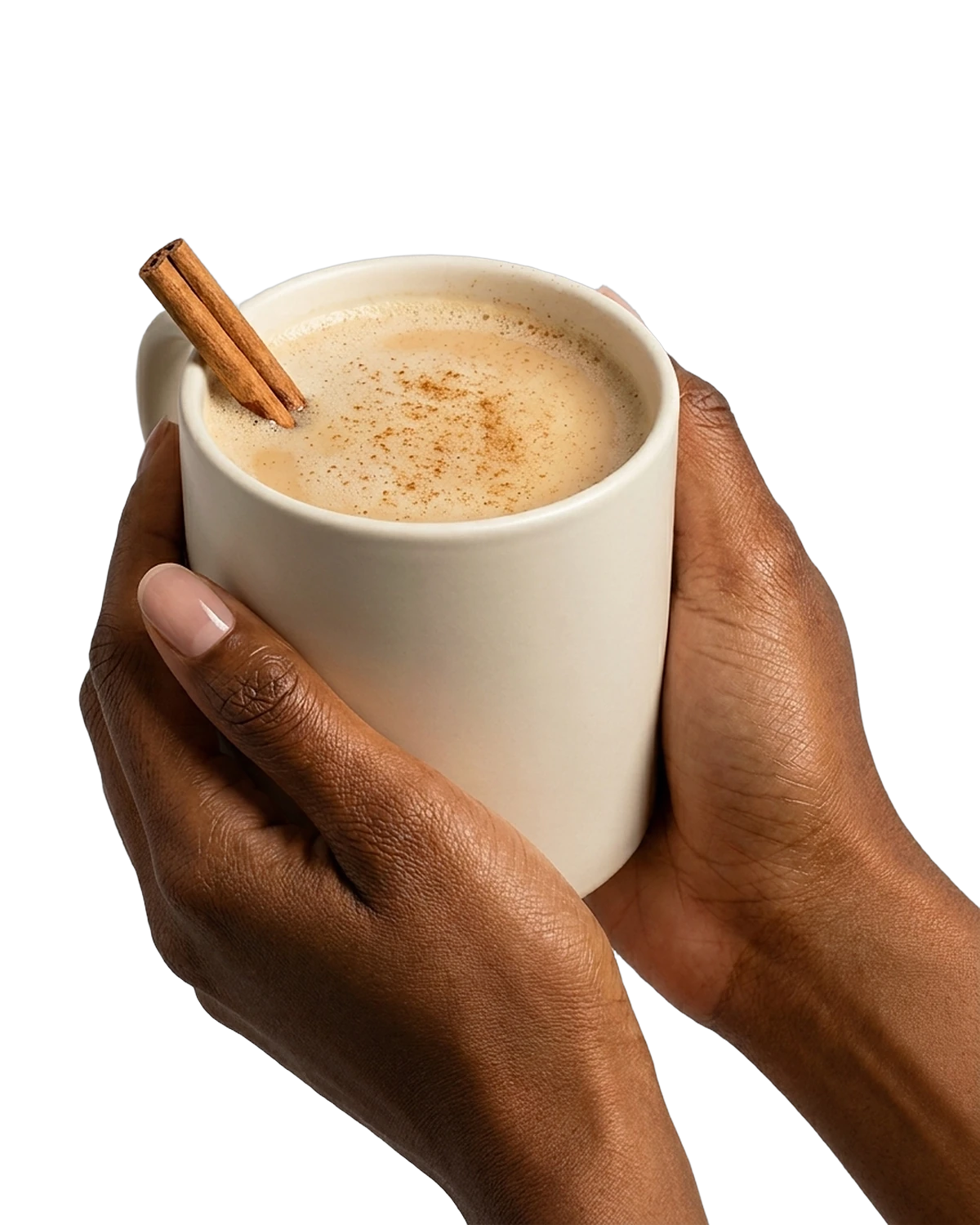 Hands around a mug of chai latte with a cinnamon stick.