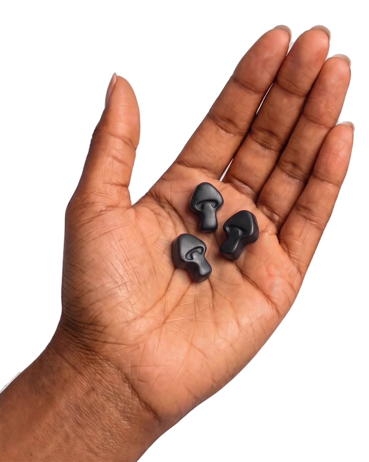 An open palm holding three mushroom-shaped gummies.
