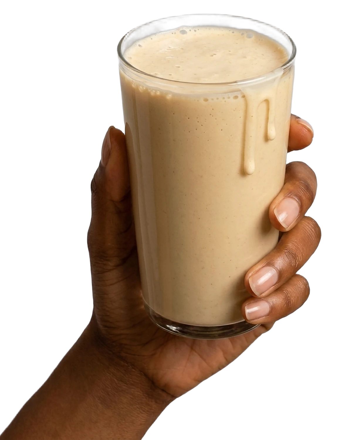 A hand holding a tall glass of creamy protein shake.