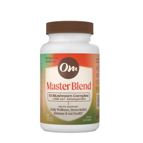 Om Master Blend capsules in front of a group of mushrooms