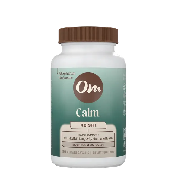 Om Calm Reishi capsules in front of a Reishi mushroom